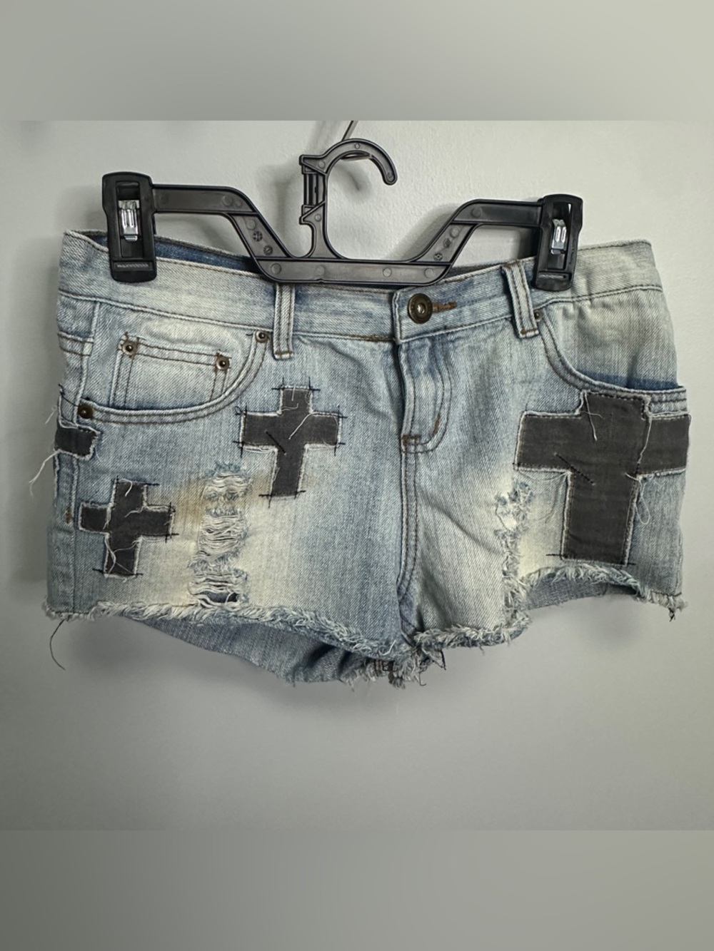ripped denim shorts with black cross design